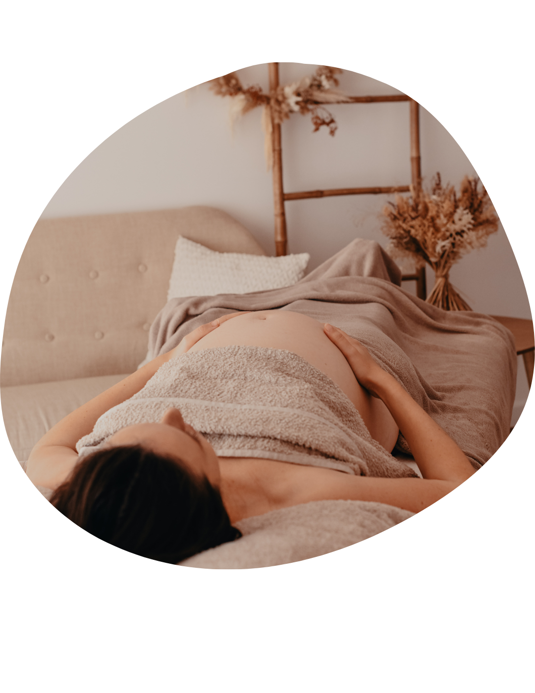 photo d'une femme enceinte allongée sur la table de massage prete a se faire masser au sein du studio de castries